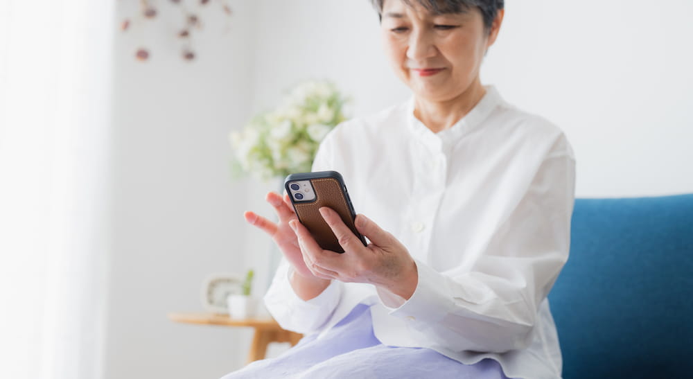 イメージ：携帯を見る高齢女性